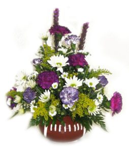 Football vase filled with bright, lavender and purple blooms