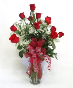 luscious array of our premium roses will surely be a hit! 12 long stemmed red roses are perfectly arranged in our clear glass vase and accented with babies breath, greenery, and a gorgeous ribbon.