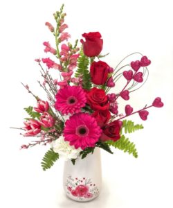 Beautiful Gerberas and roses tower over tulips and hydrangea, complete with a pink heart pick and precious ceramic container!