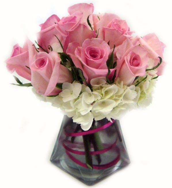ndulge her with this adorable arrangement. It is filled with white hydrangea and 12 pink roses in a glass pyramid vase.