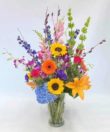 A bold and bright arrangement full of lilies, hydrangea, orchids, roses, gerberas daisies, lisanthus and much more will turn any rainy spring day into a bright and cheerful one!