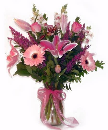 This clear vase arrives filled with pink lilies, pink gerbera daisies, pink roses, & pink snap dragons.