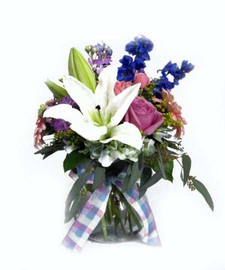 Lilies, roses, hydrangea, gerbera daisies, delphinium, stock and seeded eucalyptus arrive in this compact vase accented with a pretty ribbon.