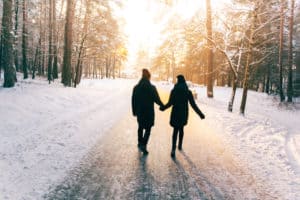 Couple walking in the snow holding hands